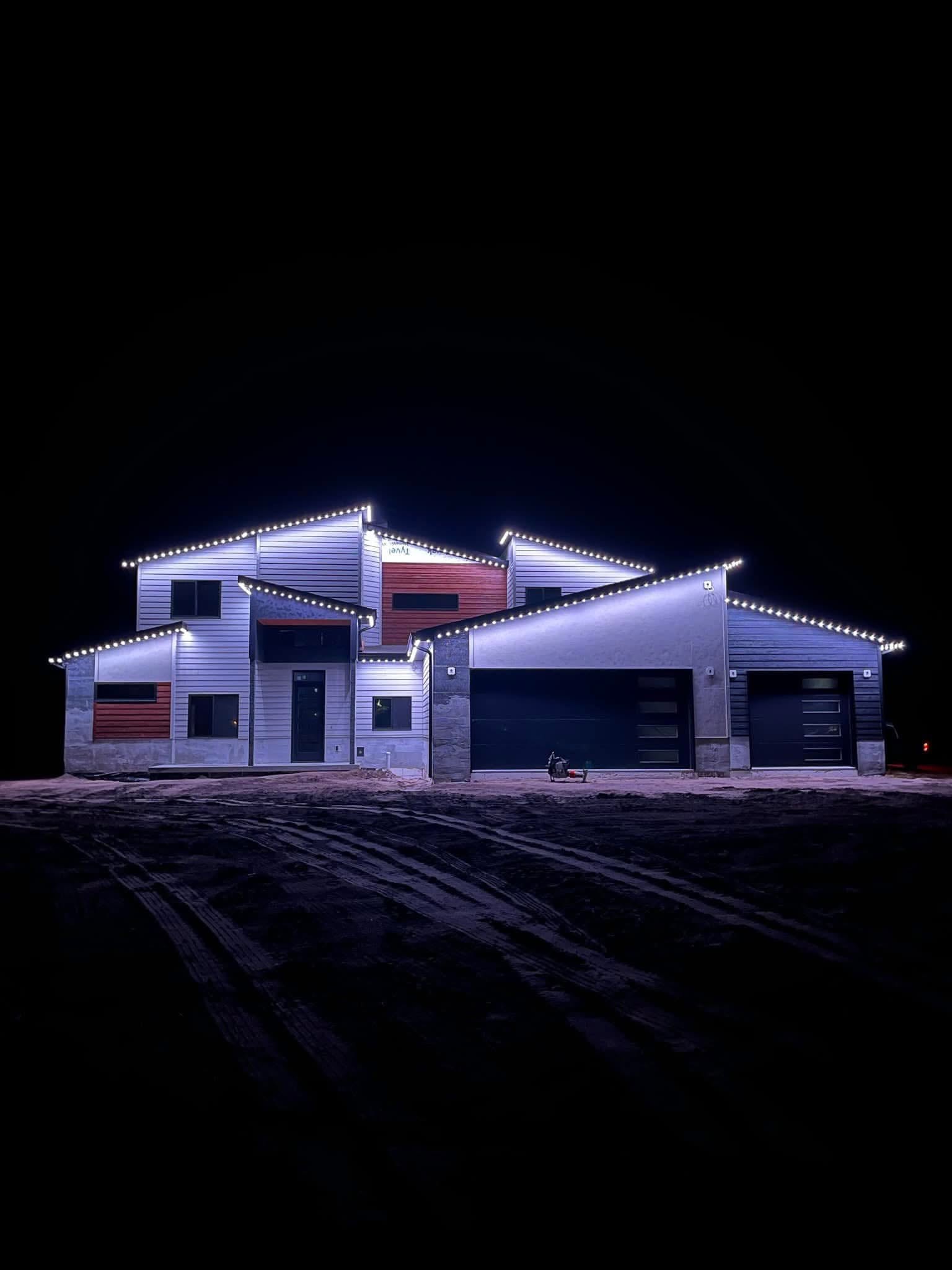 Contemporary house with illuminated rooflines against a dark sky